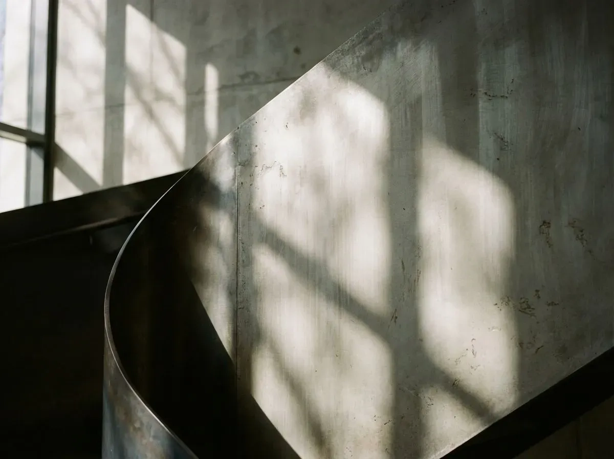 An abstract photograph showcasing the interplay of light and shadow on a sleek, modern architectural surface.